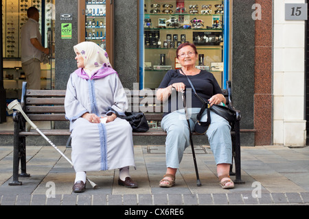 Le donne anziane seduta sul banco di lavoro. Main Street, Gibilterra, Regno Unito. Foto Stock