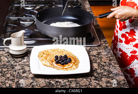 Appena sfornati pancake con mirtilli sulla parte superiore con la padella in background Foto Stock