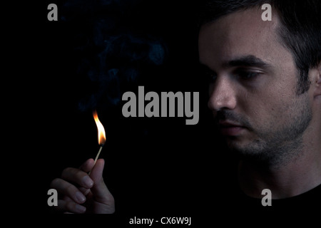 Drammatico ritratto di uomo sicurezza illuminazione corrispondono, su sfondo nero. Foto Stock