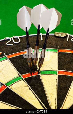 Tre freccette di punteggio con successo uno e cento ottanta in un dartboard Foto Stock