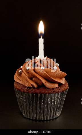 Una casa cotto al cioccolato torta di tazza con una sola candela accesa per festeggiare un compleanno o un altro anniversario Foto Stock