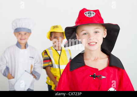 Little Boy come pompiere, lo sfondo è i bambini come chef e operaio edile Foto Stock