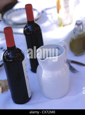 Ancora Fattoria La Vialla: Tabella con un panno bianco, sulla sommità brocca e bottiglie di vino rosso Foto Stock