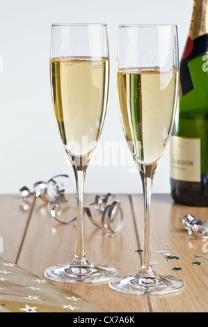 Una bottiglia e due bicchieri di champagne, con decorazione di festa. Foto Stock