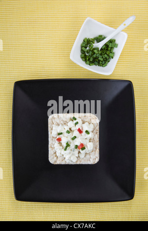 Torta di riso condito con formaggio sulla piastra nera Foto Stock