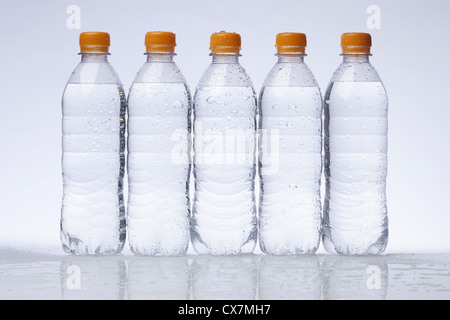 Una fila di cinque completamente in plastica di bottiglie di acqua in una riga Foto Stock