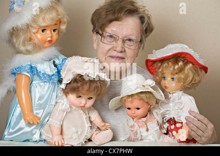 Un senior donna con la sua collezione di vecchio stile bambole Foto Stock