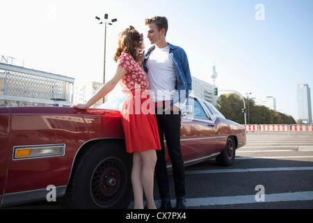 Un flirtatious rockabilly giovane in piedi accanto a un'auto d'epoca, Berlino, Germania Foto Stock
