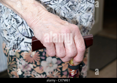 Donna anziana la mano che regge un bastone da passeggio Foto Stock