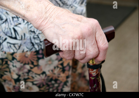 Donna anziana la mano che regge un bastone da passeggio Foto Stock