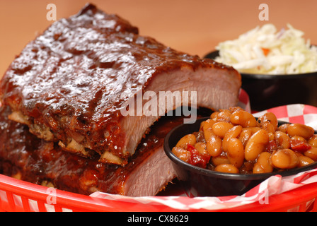 Delizioso BBQ Ribs con fagioli, cole slaw e una piccante salsa barbecue Foto Stock