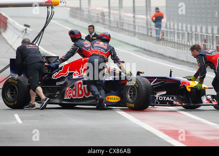 Mark Webber essendo spinto indietro dalla Red Bull meccanica in pit garage durante i test a Montmelo racing via a Barcellona, Spagna Foto Stock