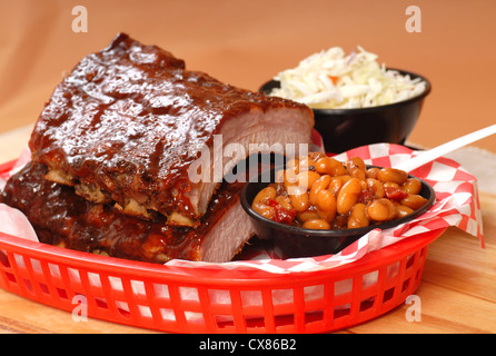 Delizioso BBQ Ribs con fagioli, cole slaw e una piccante salsa barbecue Foto Stock