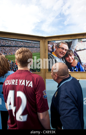 Tifosi guardare la foto-boards fuori l'Etihad Stadium e Manchester City Football Club, Manchester, Inghilterra, Regno Unito Foto Stock