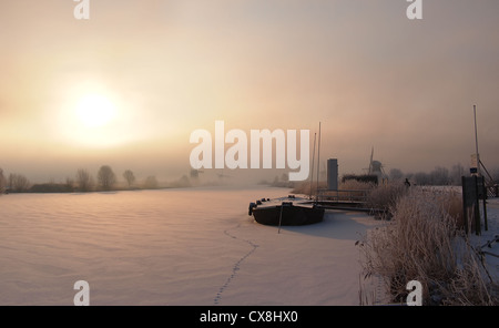 Sunrise in inverno su un canale congelati e mulini a vento in corrispondenza del famoso olandese sito UNESCO Kinderdijk, Olanda. Foto Stock