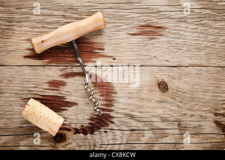 Struttura di cavatappi, sughero e le macchie di vino su sfondo di legno Foto Stock