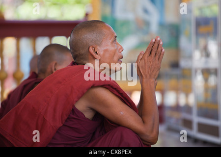 I MONACI in preghiera al KUTHODAW PAYA che ospita 729 di lastre di marmo dei Tripitaka - Mandalay, MYANMAR Foto Stock