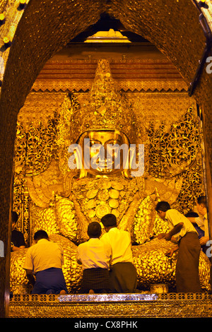 Gli uomini birmani indorare la tanto venerata BUDDHA MAHAMUNI all'interno della MAHAMUNI PAYA costruito da Re Bodwpaya nel 1784 - Mandalay, MYANMAR Foto Stock