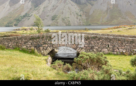 Antico ponte di pietra sul fiume che scorre in Wastwater nel Lake District Foto Stock