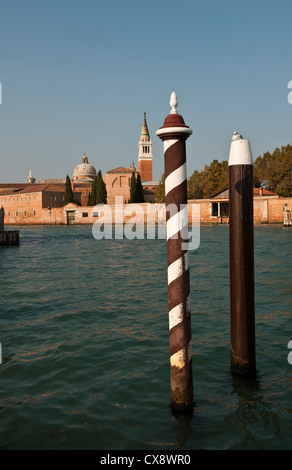 Tradizionali posti a rampino all'esterno dell'Hotel Cipriani a Venezia, con sullo sfondo la chiesa di San Giorgio maggiore Foto Stock