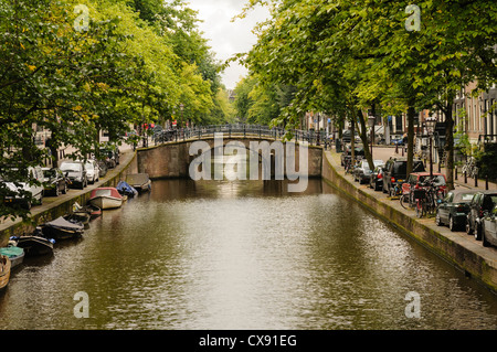 Ponte su un canale in Amsterdam con barche e biciclette Foto Stock