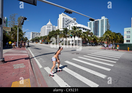 Pattinatore che attraversa la strada su Collins Avenue, South Beach, Miami Beach, Florida, Stati Uniti. Foto Stock