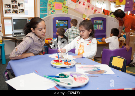 In età prescolare femmina insegnante pittura con una studentessa Foto Stock