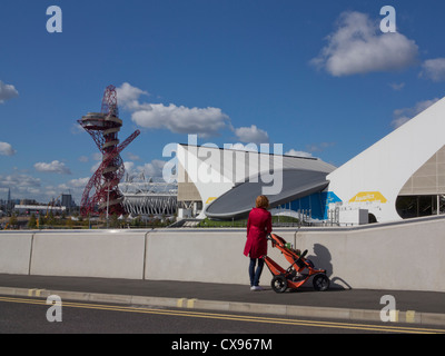 La madre e il bambino con la PRAM utilizzando una nuova strada e servizi attorno alla London 2012 Olympic Park, mostrando eredità dei giochi Foto Stock