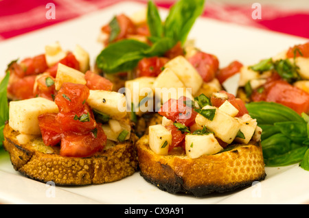 Fresh bruschetta con pomodoro mozzarella e basilico su toast sulla piastra bianca Foto Stock