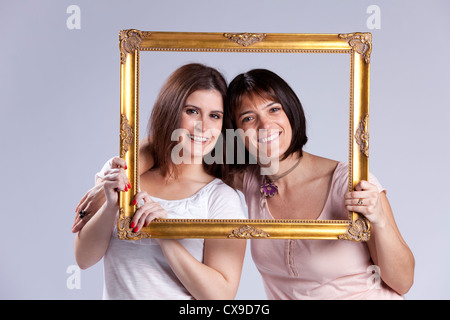 Due belle donna dentro un antico picture frame (isolato sul grigio) Foto Stock