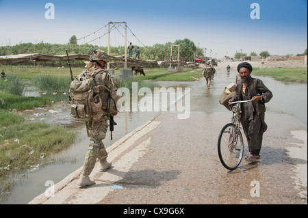 ISAF soldato Helmandi incontra l uomo a un guado: provincia di Helmand, Afghanistan Foto Stock