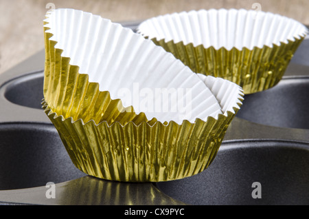 Golden Cup cake casi su una nuova teglia Foto Stock