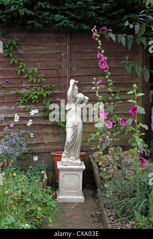 ENGLISH COUNTRY GARDEN STATUA E ALCEA, HOLLYHOCKS. Foto Stock