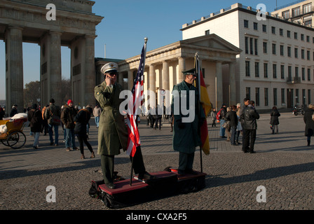 Due uomini vestiti come soldati rappresentano per i turisti in Pariser Platz davanti alla Porta di Brandeburgo a Berlino, Germania. Foto Stock