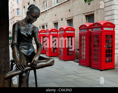 Giovane ballerino statua da Enzo Plazzotta con una fila di cabine telefoniche rosse vicino al Covent Garden Foto Stock