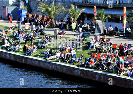 I berlinesi rilassante sulla banca del fiume Spree Berlino Germania Foto Stock