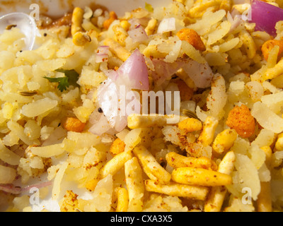 Close up Indian fast food delizia denominata europea bhel Puri, uno snack costituito da tagliare la cipolla, il peperoncino, patate bollite e riso soffiato Foto Stock