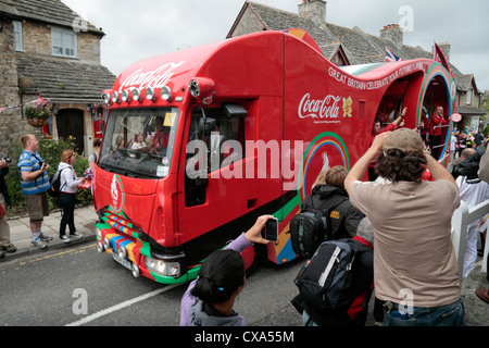 La Coca Cola bus, parte della London 2012 Giochi Olimpici relè torcia, guidando attraverso Corfe Castle, Dorset, Regno Unito. (13 luglio 2012) Foto Stock