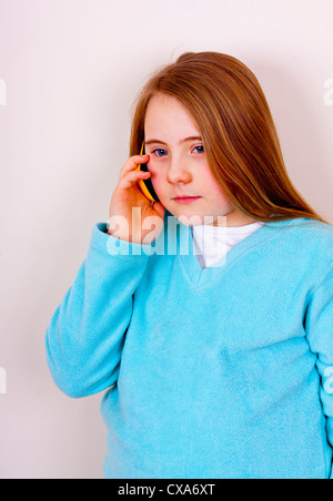 Dieci anni di ragazza utilizzando un telefono cellulare Foto Stock