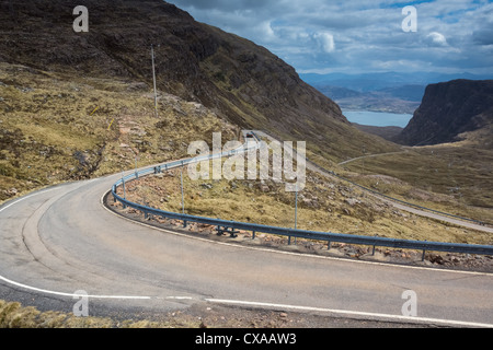 Un auto scendendo la strada tortuosa che conduce giù Bealach na Ba, Highlands Scozzesi. Foto Stock