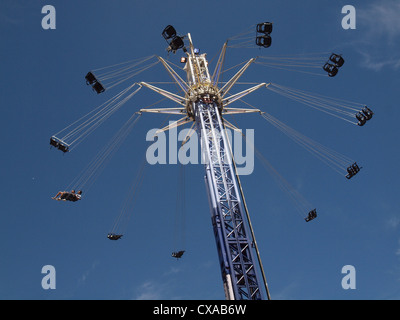 Torreggianti rotonda ride con esteso Sedili girevoli a North Greenwich contro un cielo blu con nuvole wispy Foto Stock