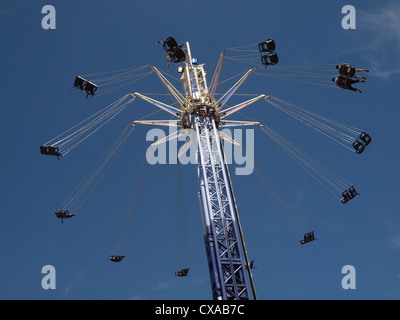 Torreggianti rotonda ride con esteso Sedili girevoli a North Greenwich contro un cielo blu con nuvole wispy Foto Stock