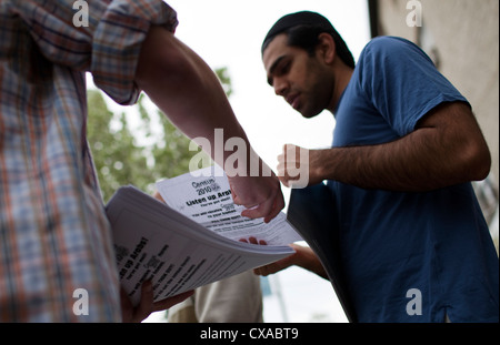 Arab-American uomini al di fuori di una moschea dopo le preghiere del venerdì prendere volantini circa la compilazione del censimento 2010 moduli. Foto Stock