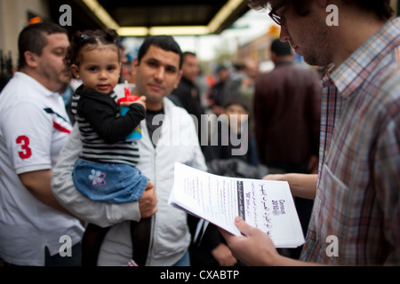 Arab-American uomini esce una moschea dopo le preghiere del venerdì prendere volantini incoraggiandoli a riempire il loro censimento 2010 moduli. Foto Stock