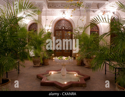 Un cortile interno con una fontana in marmo e palme presso la Villa des Orangiers a Marrakech, in Marocco, in Africa del Nord Foto Stock