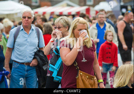 Donna di bere una pinta di sidro in folla fuori durante Abergavenny Food Festival Foto Stock