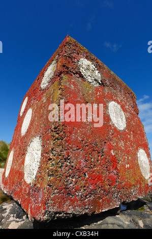 Giganteschi cubi di calcestruzzo trovato sulla spiaggia Bamburgh in Northumberland dipinta come dadi rossi. Foto Stock