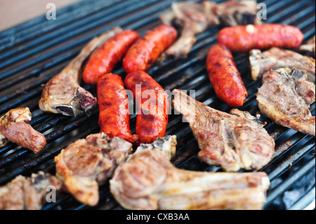 Salsicce e costolette su un barbecue Foto Stock