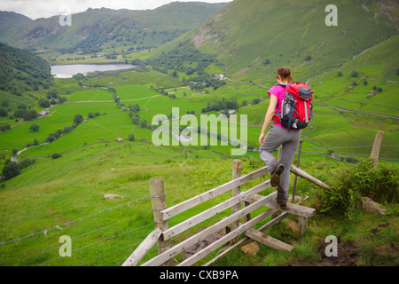 Una femmina di escursionista Alta discendente Hartsop Dodd nel distretto del lago. Fratelli acqua può essere visto in lontananza. Foto Stock