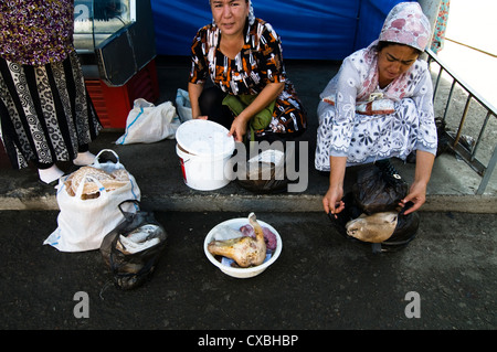 Locali di donne uzbeke vendere la carne a Tashkent il bazaar Chorsu. Foto Stock